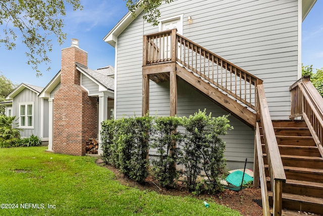 view of property exterior with a deck and a lawn