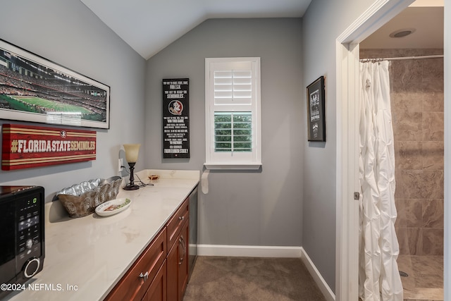 bathroom with lofted ceiling, a shower with shower curtain, and vanity