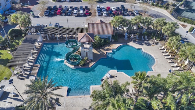 view of pool with a water slide and a patio