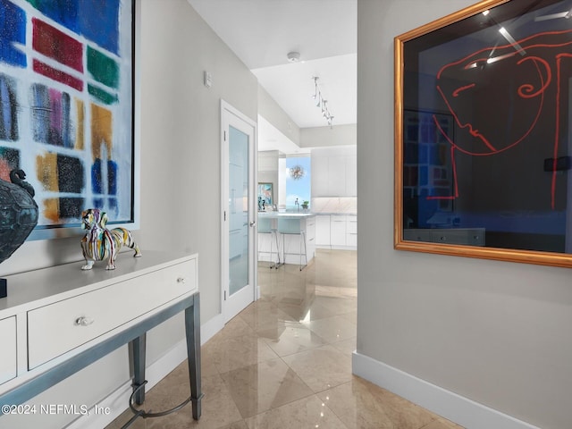 hallway with sink and rail lighting