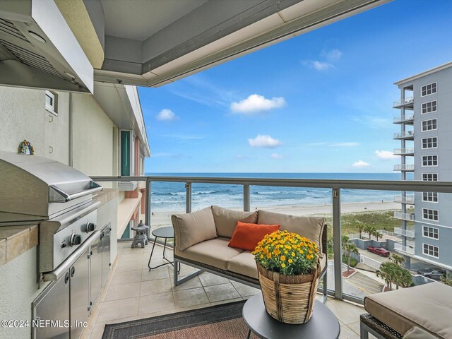 balcony with a beach view, a grill, and a water view