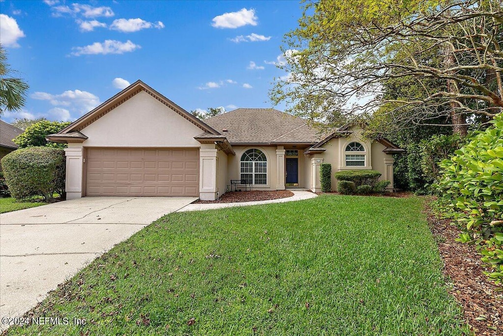 view of front of home featuring a front yard and a garage