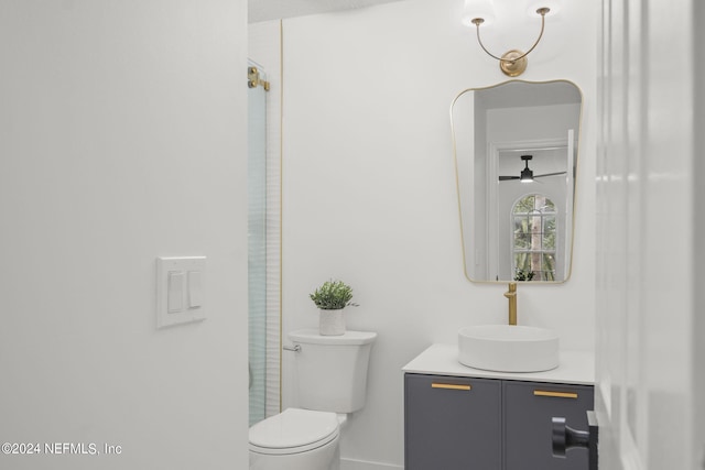 bathroom featuring toilet, vanity, and ceiling fan