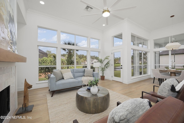 sunroom with a high end fireplace and ceiling fan