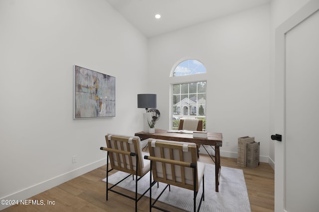 office space with light hardwood / wood-style flooring and high vaulted ceiling