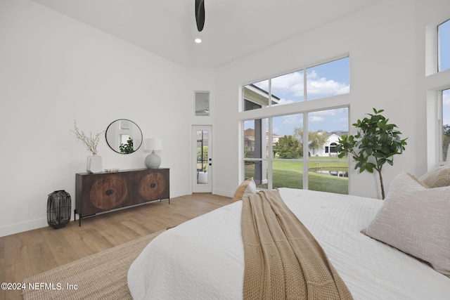 bedroom featuring wood-type flooring and a towering ceiling