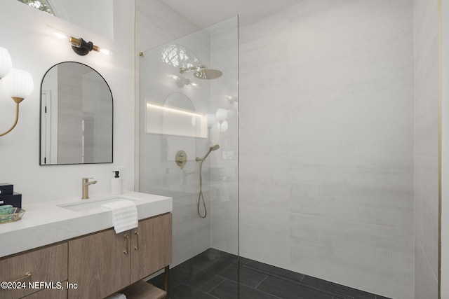 bathroom with vanity, a tile shower, and tile patterned flooring