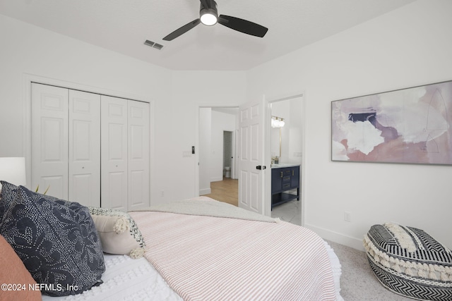 carpeted bedroom featuring connected bathroom, ceiling fan, and a closet