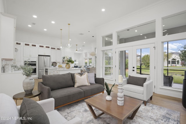 living room with light hardwood / wood-style floors, french doors, and ornamental molding