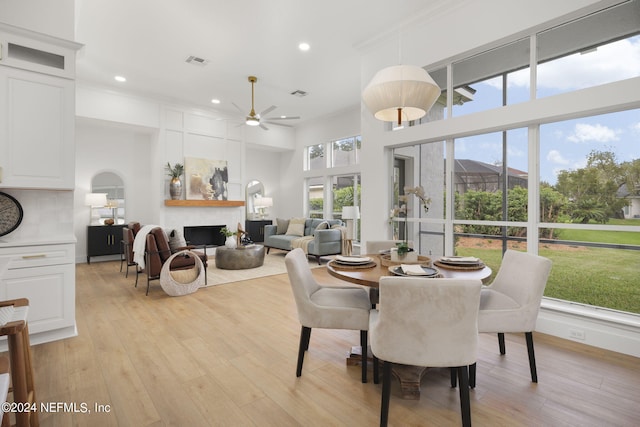 dining area with light hardwood / wood-style flooring, ornamental molding, and ceiling fan