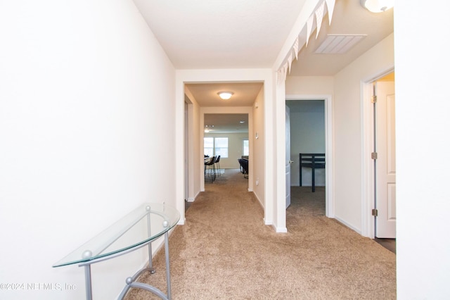 hall with light colored carpet