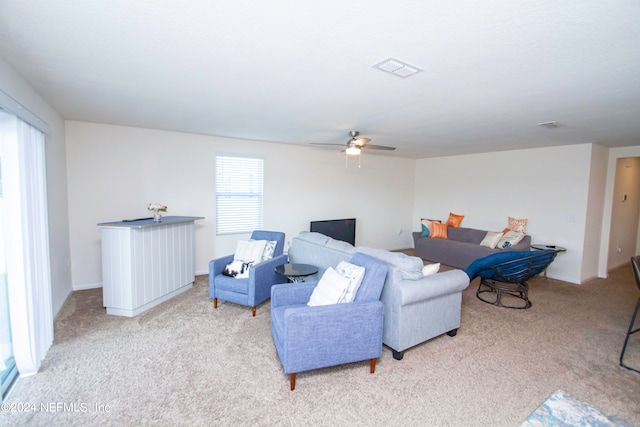 living room with light colored carpet and ceiling fan