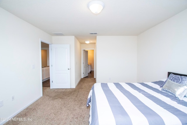 bedroom with light carpet and ensuite bathroom