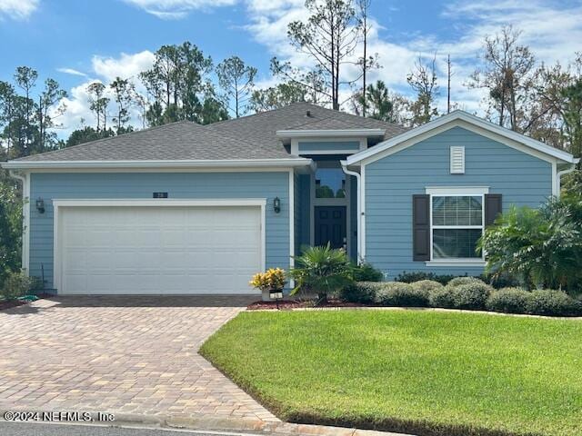 view of front of property with a garage and a front lawn