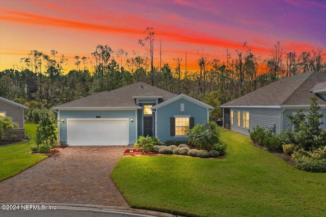 ranch-style house with a yard and a garage