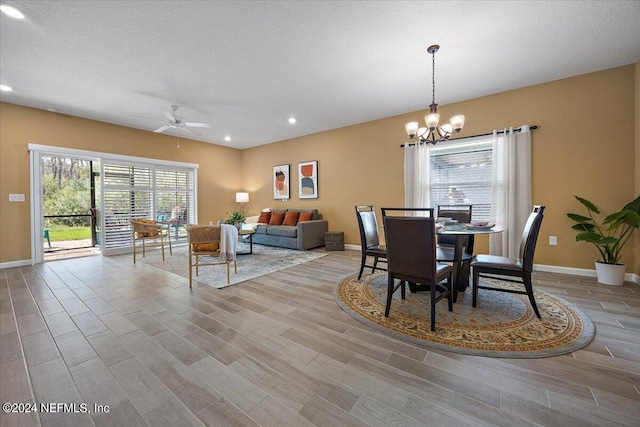 dining room featuring a textured ceiling, ceiling fan with notable chandelier, and light hardwood / wood-style flooring