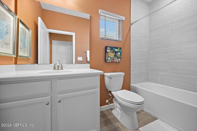 full bathroom featuring tile patterned floors, vanity, tiled shower / bath combo, and toilet