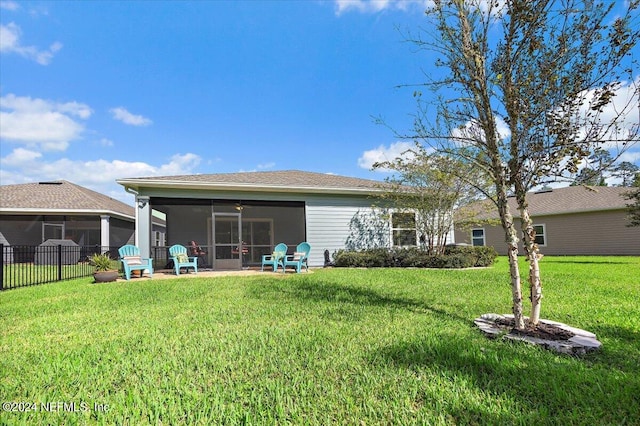 rear view of property with a sunroom and a lawn