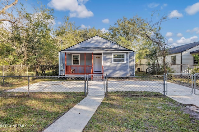 bungalow-style home featuring covered porch and a front yard