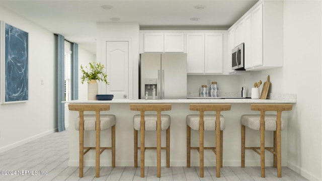 kitchen featuring white refrigerator with ice dispenser, light wood-type flooring, white cabinets, and a breakfast bar