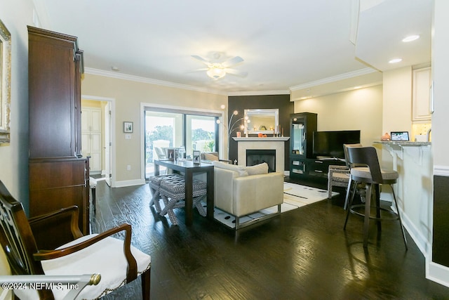 living room with dark wood-type flooring, crown molding, and ceiling fan