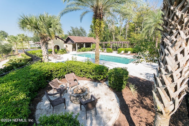 view of swimming pool with a patio and a fire pit