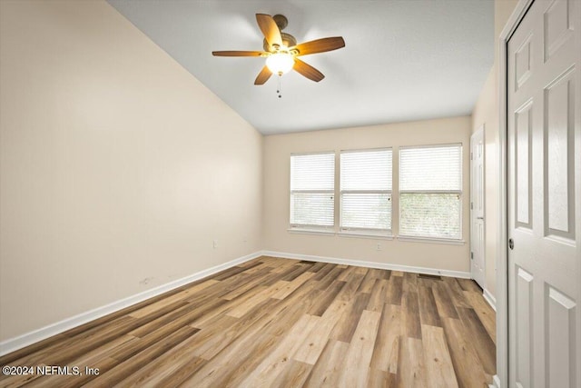 empty room featuring vaulted ceiling, light hardwood / wood-style floors, and ceiling fan