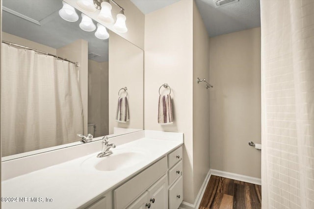 bathroom featuring vanity, walk in shower, toilet, and wood-type flooring