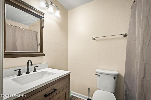 bathroom featuring vanity, a shower with shower curtain, and toilet