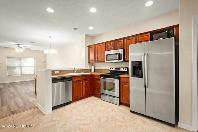 kitchen with light hardwood / wood-style flooring, sink, ceiling fan with notable chandelier, pendant lighting, and stainless steel appliances