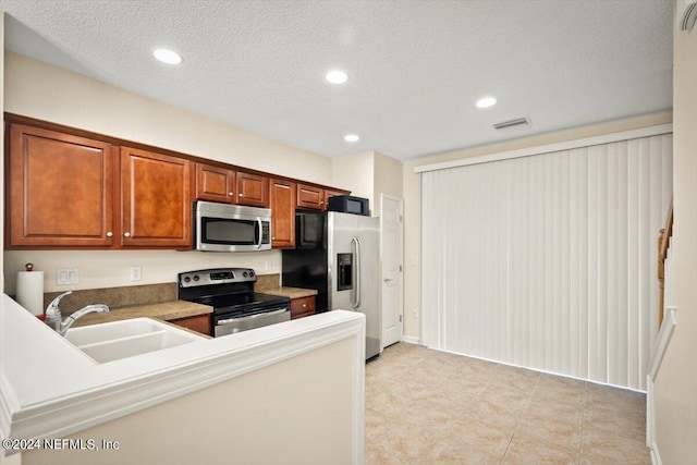 kitchen featuring sink, stainless steel appliances, and a textured ceiling