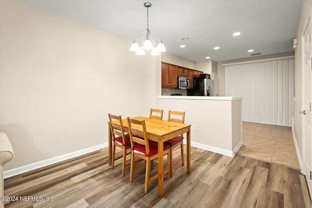 dining area featuring a notable chandelier and light wood-type flooring