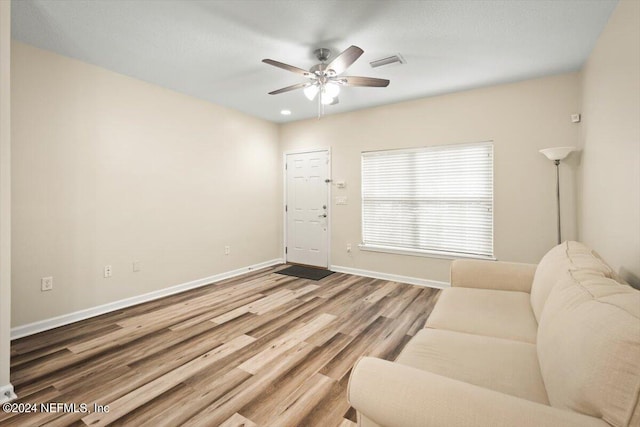 living room featuring hardwood / wood-style floors and ceiling fan