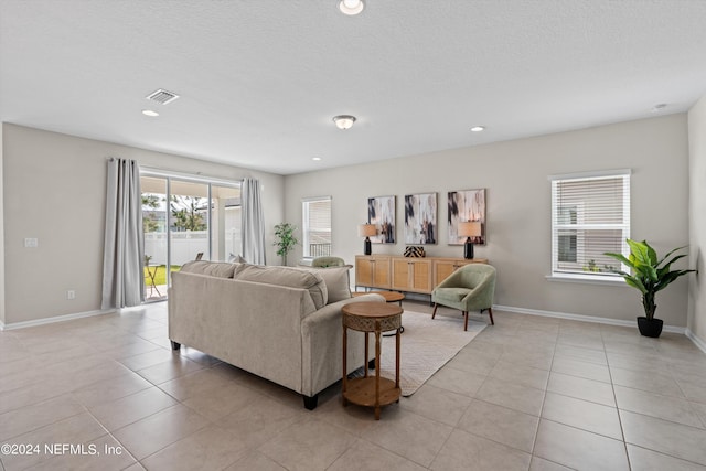 tiled living room featuring a textured ceiling