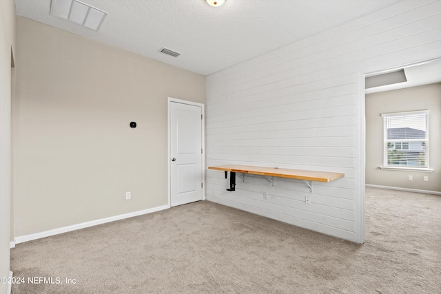 spare room with a textured ceiling and light carpet