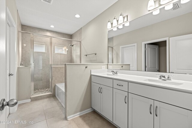 bathroom featuring plus walk in shower, tile patterned floors, and vanity