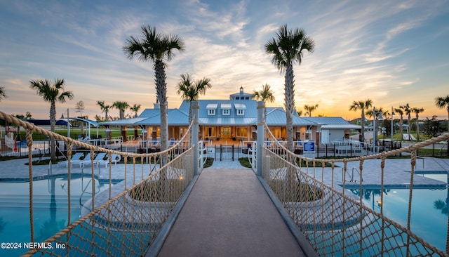 view of dock featuring a community pool, a patio, and a balcony