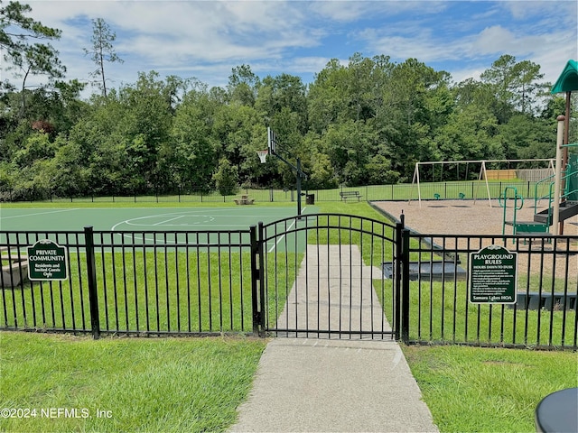 exterior space featuring basketball hoop, a playground, and a lawn