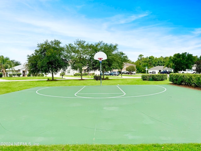 view of sport court with a lawn