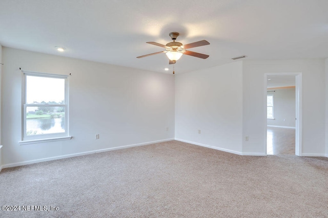 carpeted spare room featuring ceiling fan