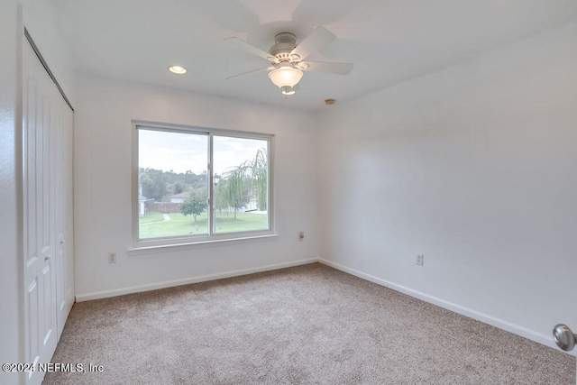 carpeted empty room featuring ceiling fan