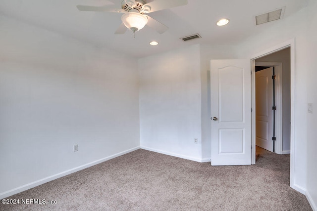 carpeted spare room with ceiling fan