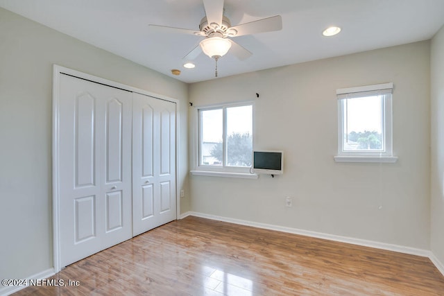 unfurnished bedroom with light hardwood / wood-style flooring, a closet, and ceiling fan