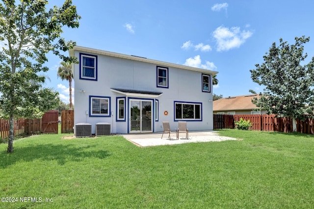 rear view of property featuring a yard, central AC, and a patio area