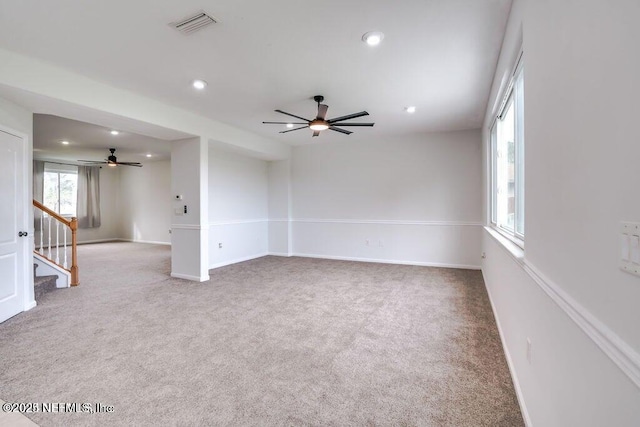 carpeted spare room featuring ceiling fan