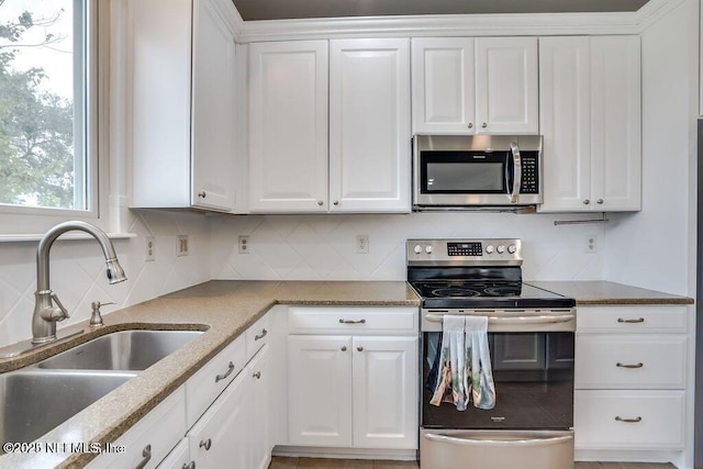 kitchen with white cabinets, backsplash, sink, and appliances with stainless steel finishes