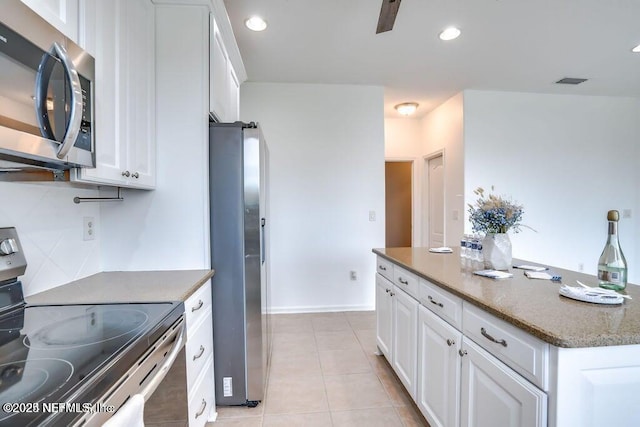 kitchen featuring stone counters, light tile patterned flooring, white cabinetry, and appliances with stainless steel finishes