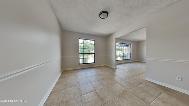 tiled spare room with a textured ceiling