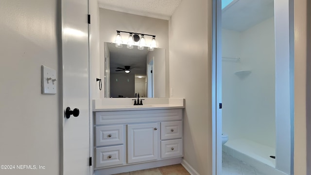 bathroom with vanity, toilet, a textured ceiling, walk in shower, and tile patterned flooring