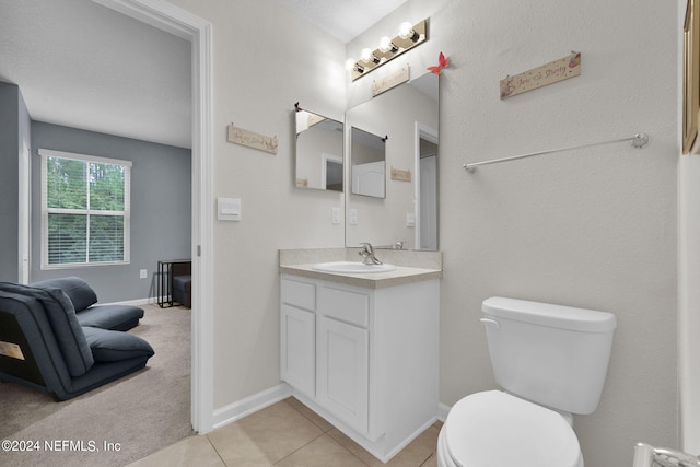 bathroom featuring tile patterned floors, vanity, toilet, and a textured ceiling